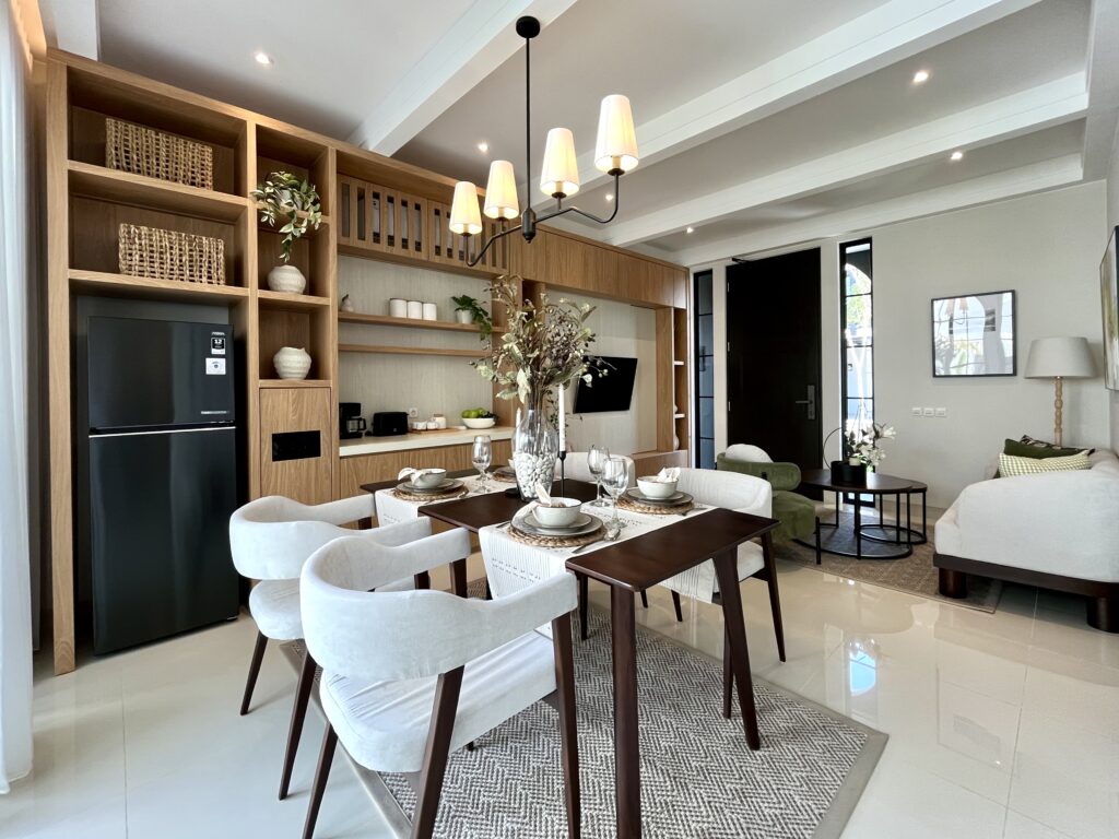 Open-concept dining area with wooden shelving, a hanging chandelier, and a table set for six.